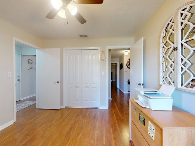 bedroom with ceiling fan, dark hardwood / wood-style floors, and a closet