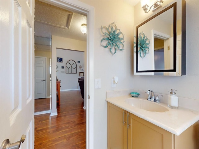 bathroom featuring a textured ceiling, wood-type flooring, and vanity