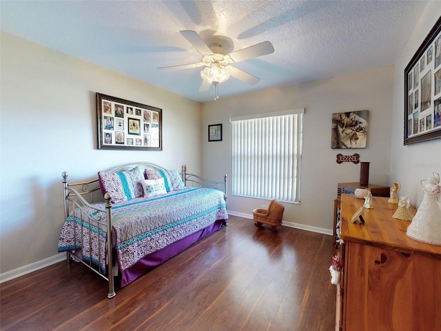 bedroom with a textured ceiling, ceiling fan, and dark hardwood / wood-style floors