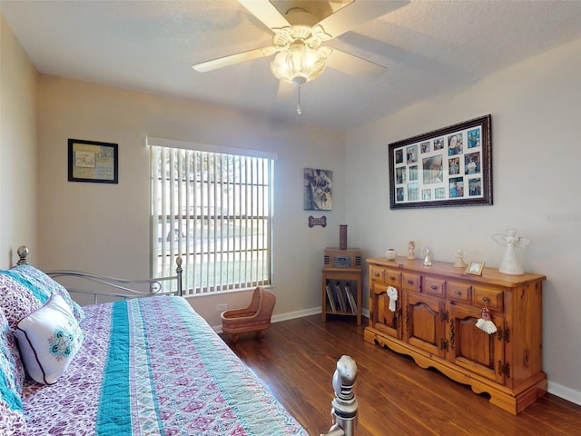 bedroom with ceiling fan, dark wood-type flooring, and a textured ceiling