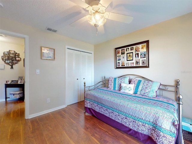 bedroom with a textured ceiling, a closet, ceiling fan, and wood-type flooring