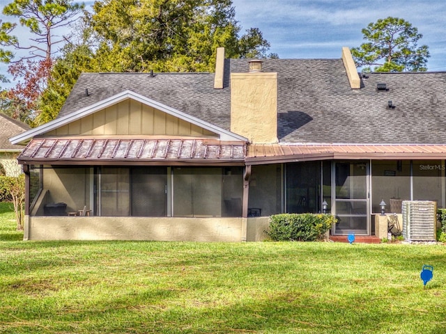 back of house featuring a yard and a sunroom