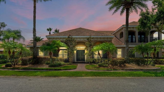 mediterranean / spanish house with a tile roof and stucco siding