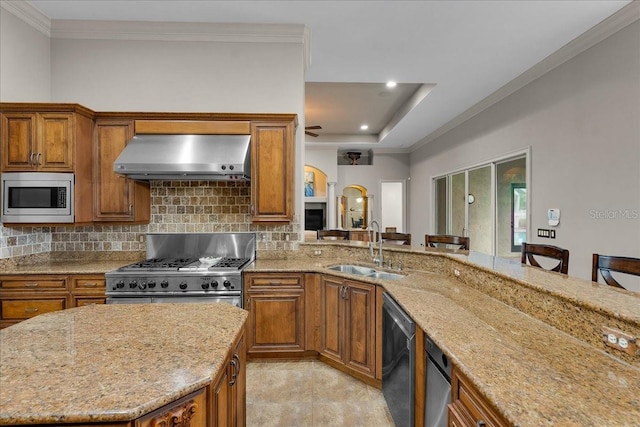 kitchen featuring appliances with stainless steel finishes, brown cabinets, a sink, and ventilation hood