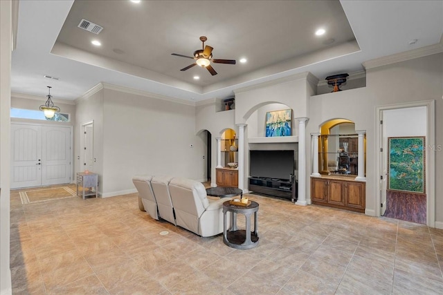 living room with visible vents, a raised ceiling, arched walkways, ceiling fan, and crown molding