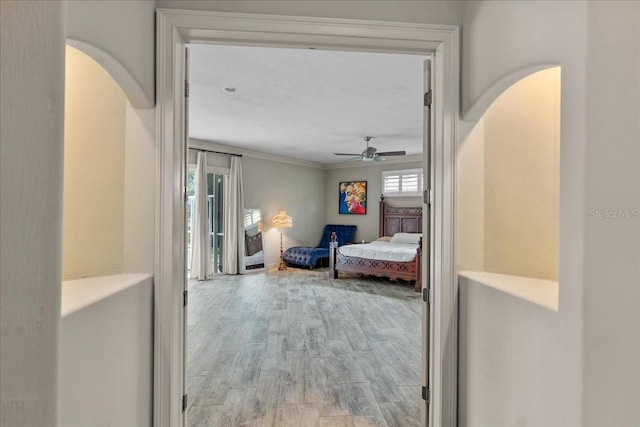 bedroom with arched walkways, wood finished floors, a ceiling fan, access to outside, and ornamental molding