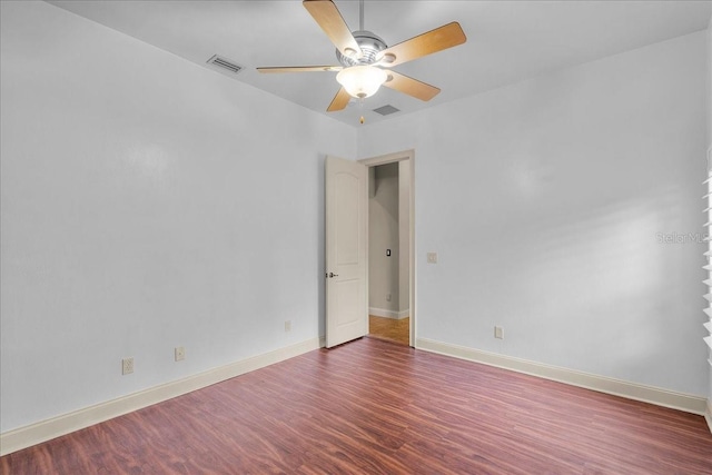 empty room featuring visible vents, wood finished floors, a ceiling fan, and baseboards