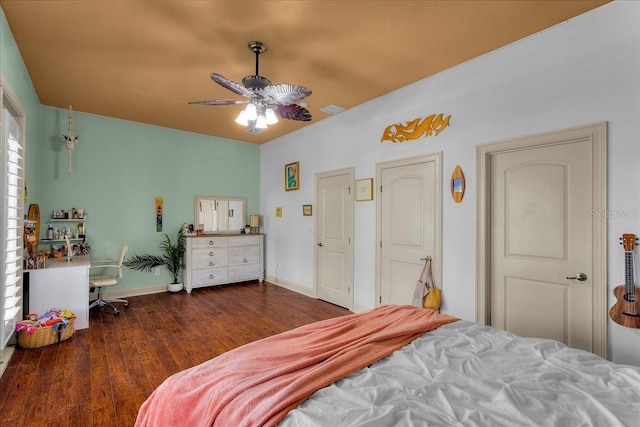 bedroom with a ceiling fan, visible vents, baseboards, and wood finished floors