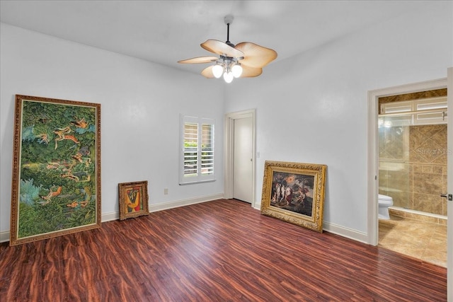 unfurnished living room with ceiling fan, baseboards, and wood finished floors