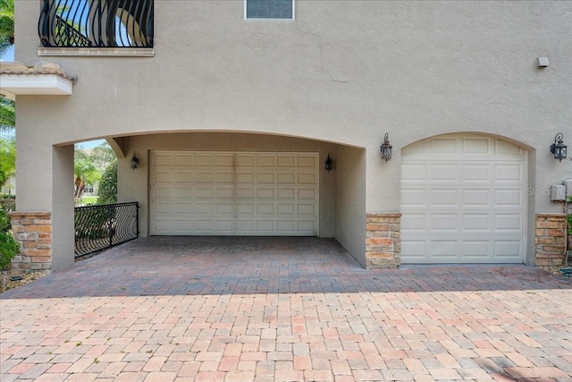 garage with decorative driveway