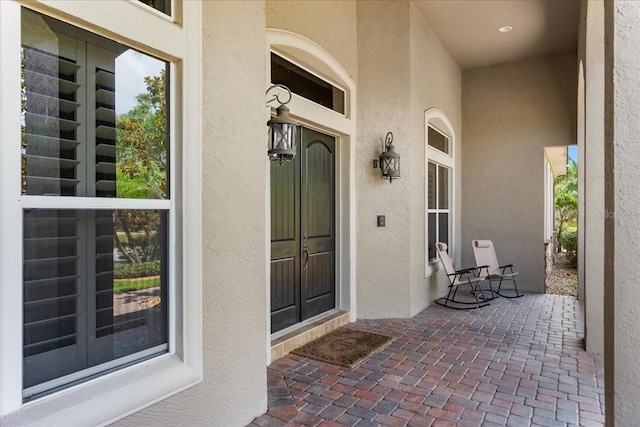 doorway to property featuring stucco siding