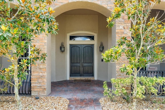 property entrance with stone siding and stucco siding