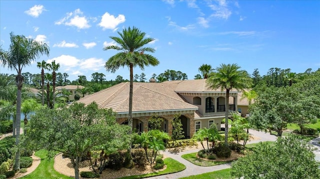 view of front of property featuring driveway, a tile roof, and stucco siding