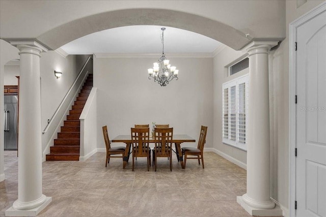 dining area featuring a chandelier, baseboards, crown molding, and ornate columns