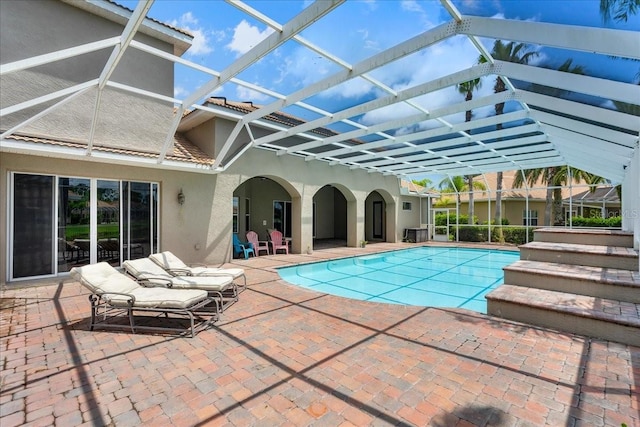 pool featuring glass enclosure and a patio