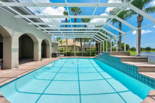 outdoor pool with a patio area and glass enclosure