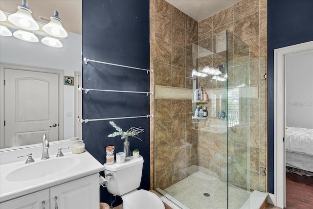 bathroom featuring connected bathroom, a shower stall, toilet, and vanity