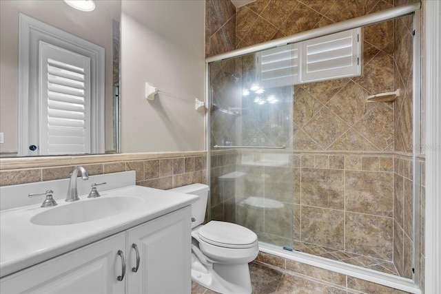 full bath featuring tile walls, a shower stall, toilet, and vanity