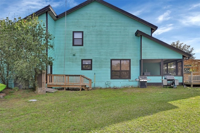 rear view of house with a sunroom and a yard