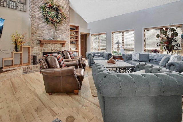 living room featuring built in shelves, a fireplace, high vaulted ceiling, and light hardwood / wood-style flooring