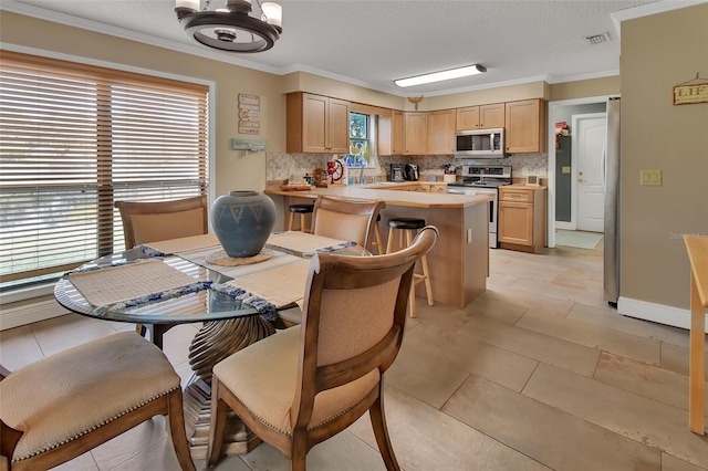 tiled dining room with ornamental molding, a textured ceiling, and a wealth of natural light