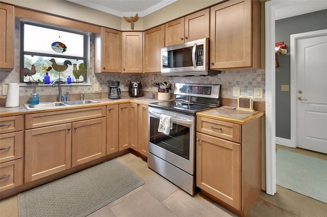 kitchen with crown molding, sink, decorative backsplash, light tile patterned floors, and appliances with stainless steel finishes