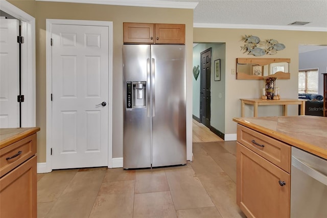 kitchen featuring a textured ceiling, light tile patterned flooring, crown molding, and appliances with stainless steel finishes