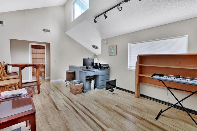 office featuring rail lighting, light hardwood / wood-style floors, and lofted ceiling