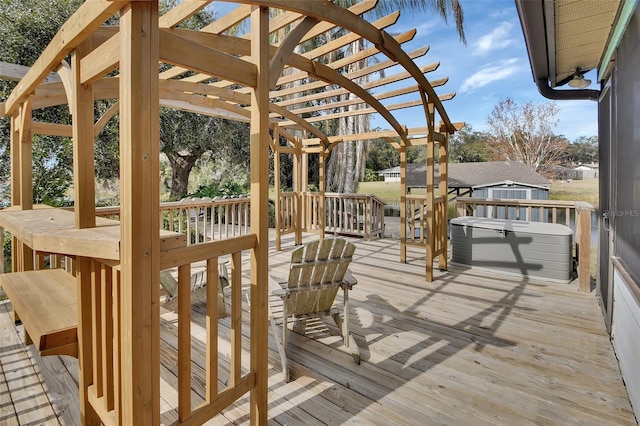 wooden deck with a pergola and a hot tub