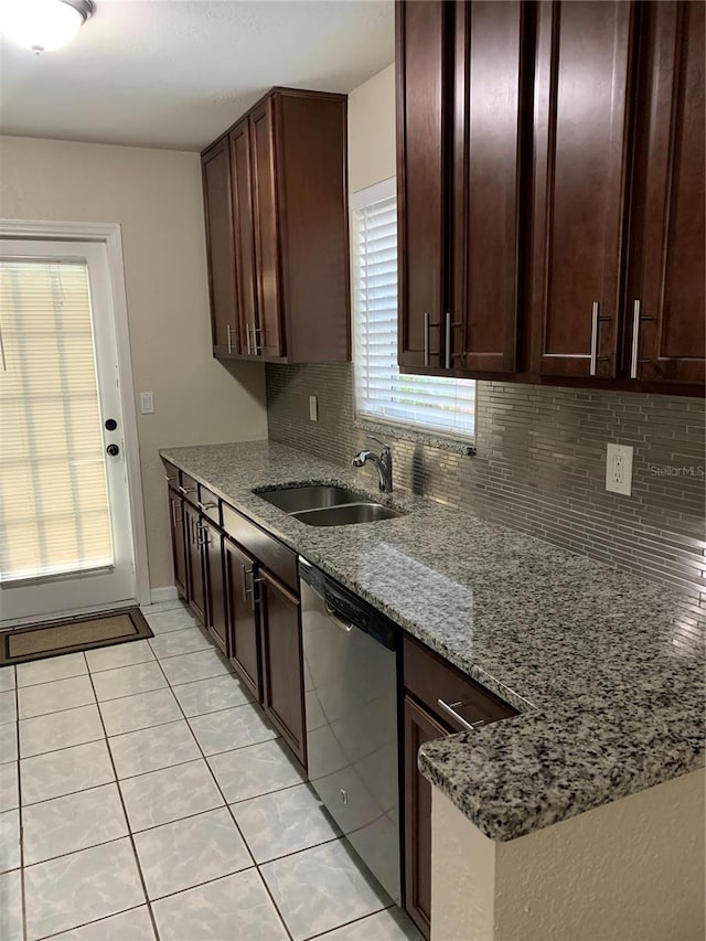 kitchen with sink, decorative backsplash, stainless steel dishwasher, light tile patterned floors, and light stone countertops