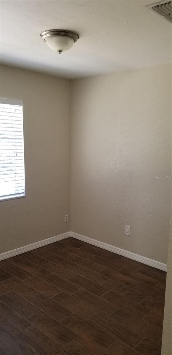 unfurnished room featuring dark wood-type flooring