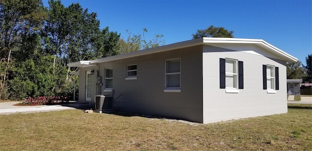 view of property exterior featuring cooling unit and a lawn