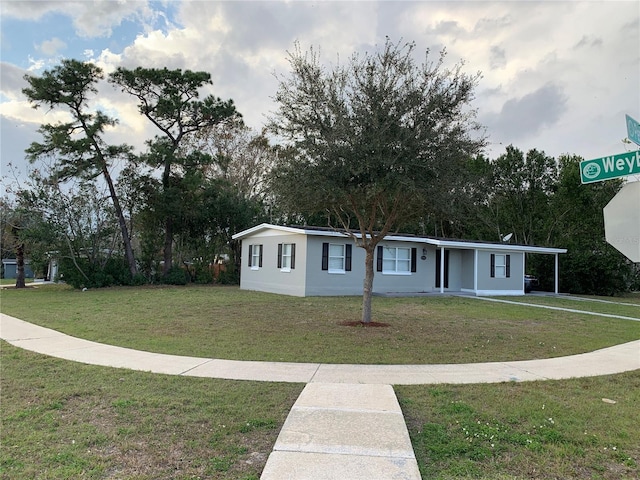 view of front of home with a carport and a front yard