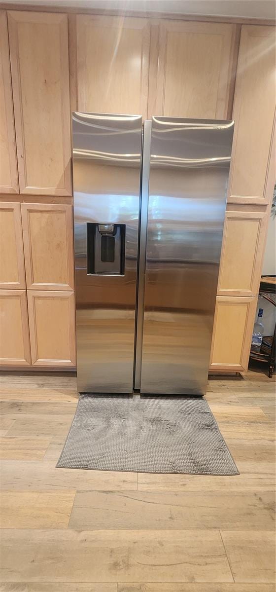 kitchen featuring light brown cabinetry, light hardwood / wood-style floors, and stainless steel refrigerator with ice dispenser