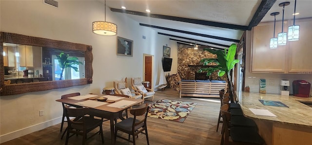 dining space featuring dark hardwood / wood-style flooring and vaulted ceiling with beams