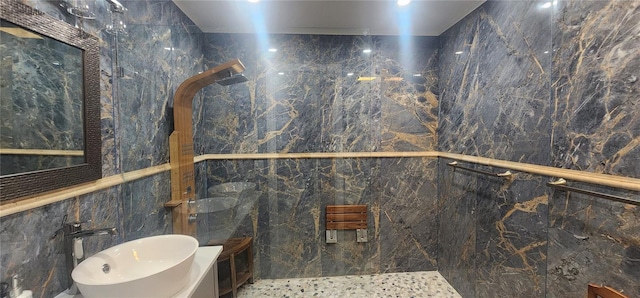 bathroom with a shower, sink, and tile walls