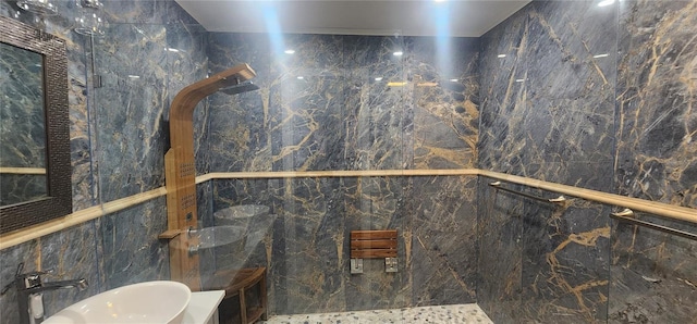 bathroom featuring a shower, tile walls, and sink