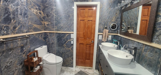 bathroom featuring vanity, tile walls, and toilet