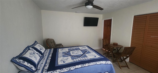 bedroom with tile patterned flooring, a closet, and ceiling fan