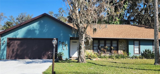 view of front facade with an attached garage, driveway, roof with shingles, and a front yard