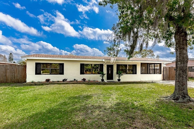 ranch-style home with stucco siding, fence, and a front yard