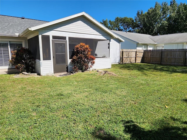 back of house featuring a sunroom and a yard