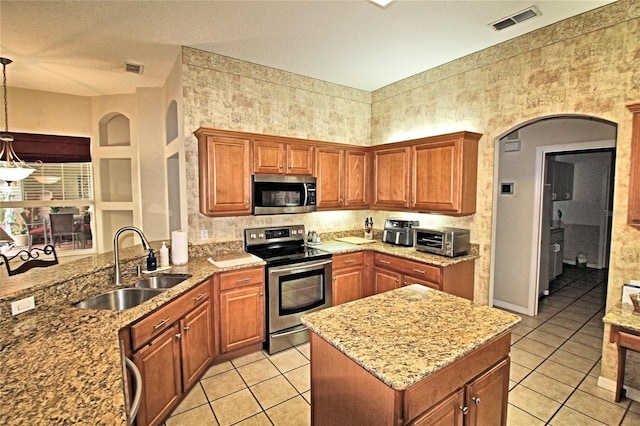 kitchen featuring light stone countertops, sink, stainless steel appliances, pendant lighting, and light tile patterned floors