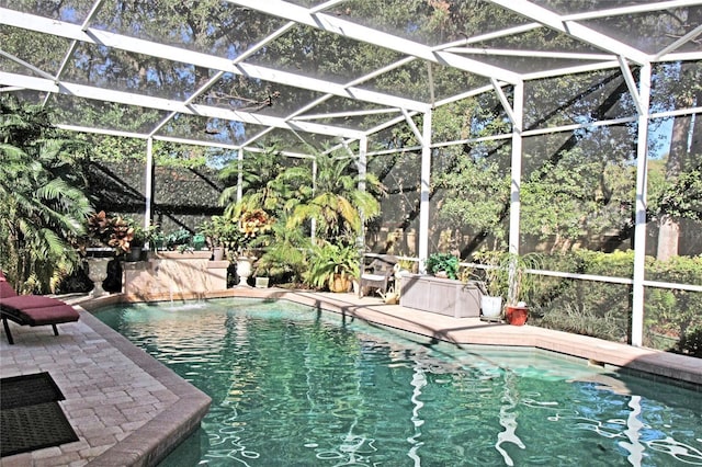 view of pool featuring pool water feature, a patio area, and a lanai