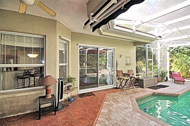 sunroom with ceiling fan and a pool