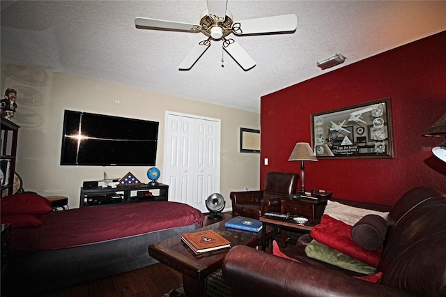 bedroom featuring ceiling fan, a closet, a textured ceiling, and hardwood / wood-style flooring