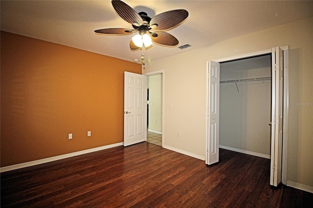 unfurnished bedroom with ceiling fan, a closet, and dark wood-type flooring