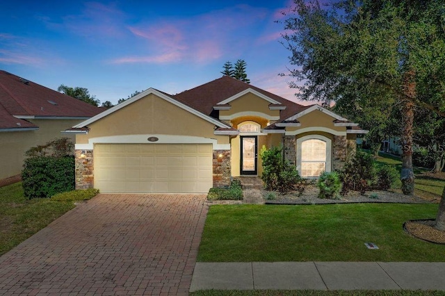 view of front of property featuring a garage and a yard