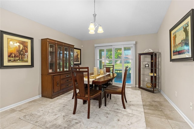 tiled dining room with an inviting chandelier