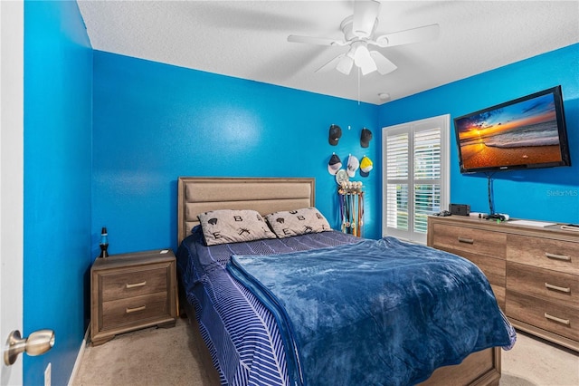 carpeted bedroom featuring ceiling fan and a textured ceiling